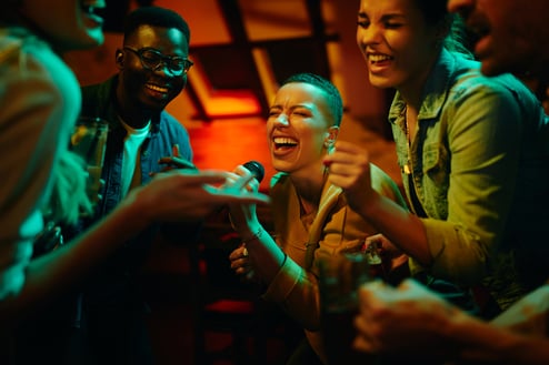 group-of-happy-friends-singing-karaoke-during-a-ni-2023-11-27-04-58-37-utc