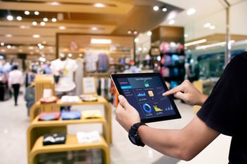 A retail team member working on a tablet, meant to represent the significance of retail media measurement.