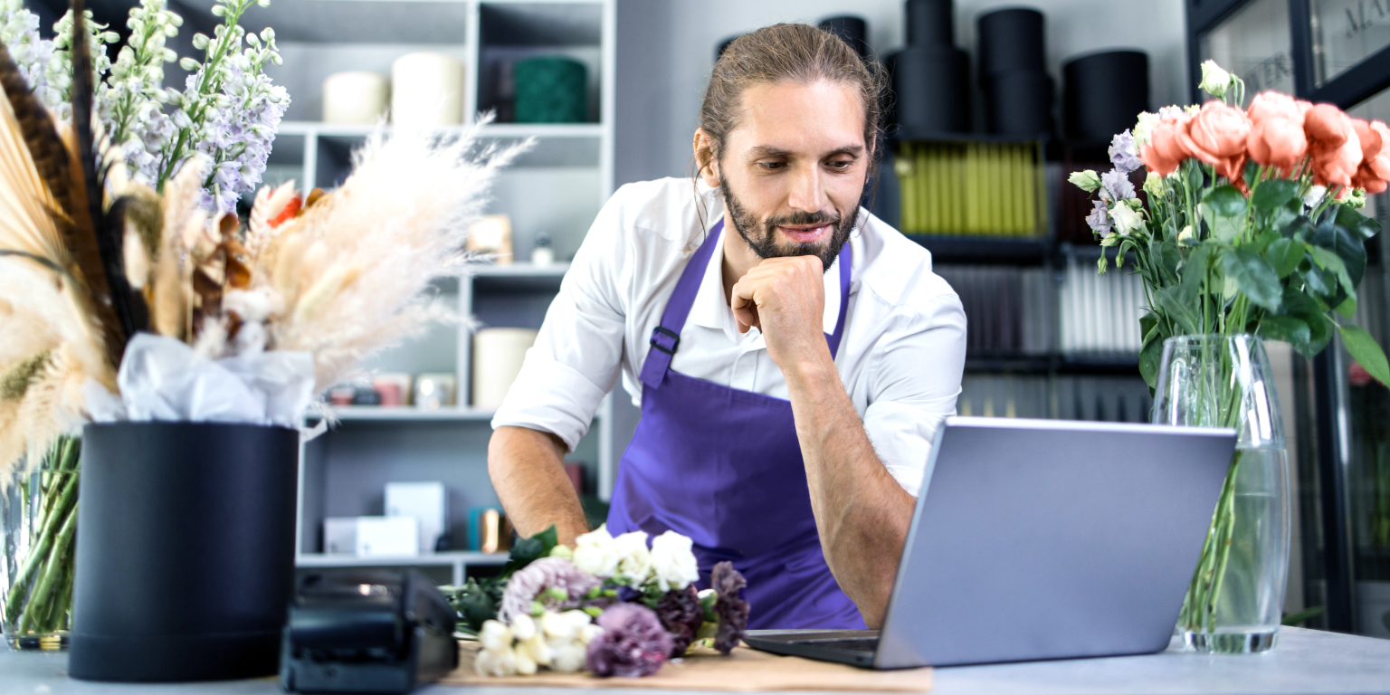 Man looking at digital signage reports in retail store