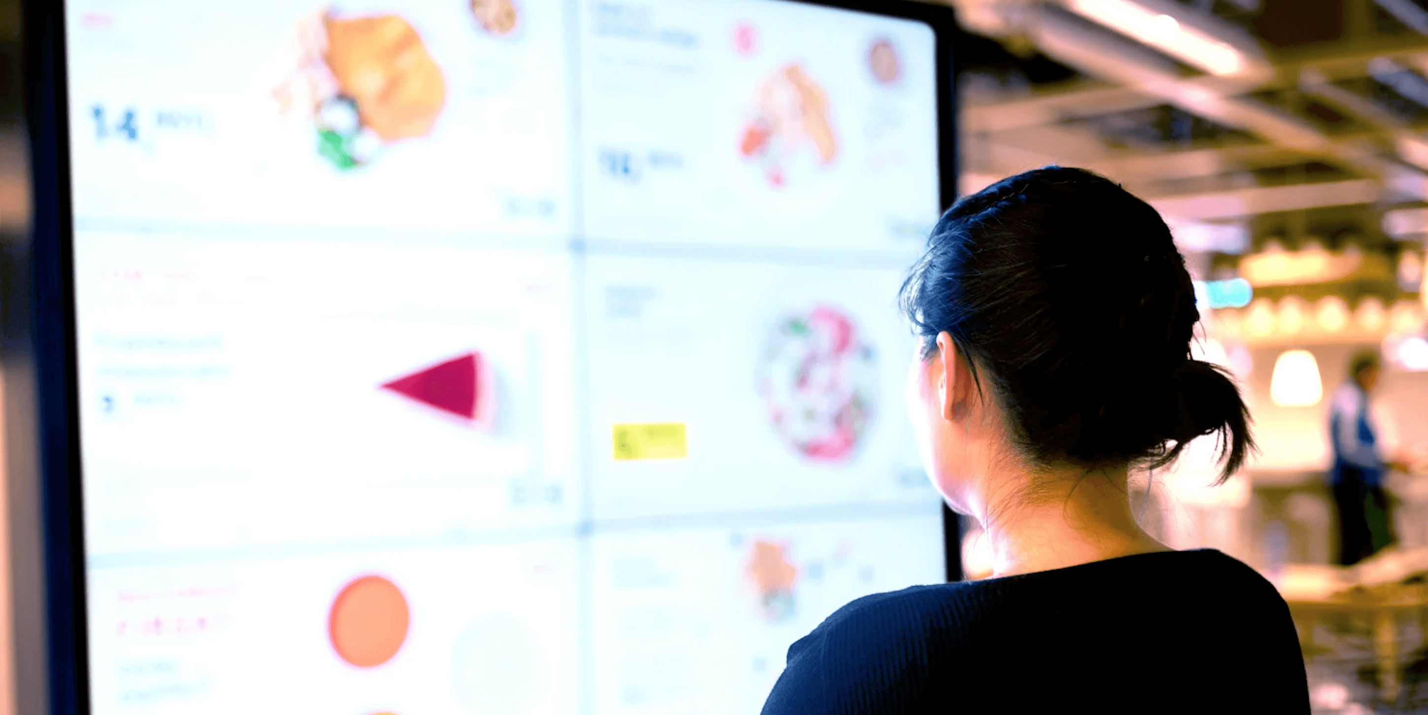 Woman looking at a digital menu board for restaurants, meant to indicate the power of digital signage